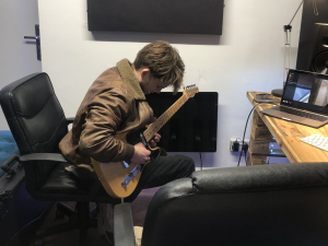 NFC Staff member playing guitar in the studio